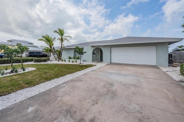 7092 S Shore Dr S, Saint Petersburg, FL 33707 - ranch-style home with stucco siding, concrete driveway, a garage, and a front yard