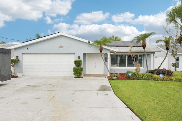 6010 Bayou Grande Blvd NE, Saint Petersburg, FL 33703 - single story home with stucco siding, a front yard, solar panels, concrete driveway, and an attached garage