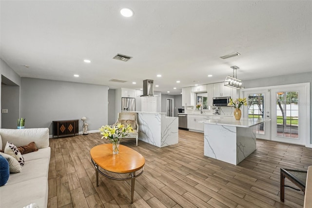 6010 Bayou Grande Blvd NE, Saint Petersburg, FL 33703 - living room with light wood finished floors, recessed lighting, and french doors