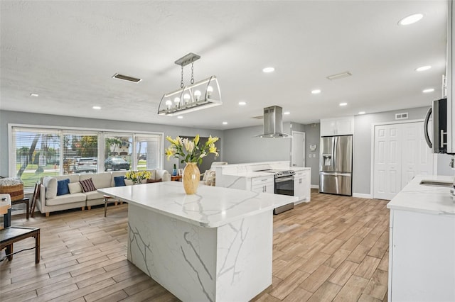 6010 Bayou Grande Blvd NE, Saint Petersburg, FL 33703 - kitchen with stainless steel appliances, island exhaust hood, an island with sink, light wood-style flooring, and open floor plan