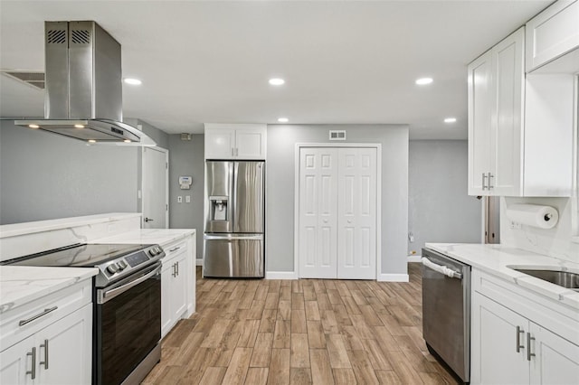 6010 Bayou Grande Blvd NE, Saint Petersburg, FL 33703 - kitchen featuring stainless steel appliances, island range hood, light wood finished floors, white cabinets, and recessed lighting