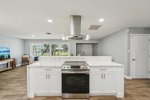 6010 Bayou Grande Blvd NE, Saint Petersburg, FL 33703 - kitchen with stainless steel electric stove, island exhaust hood, light stone countertops, light wood finished floors, and recessed lighting