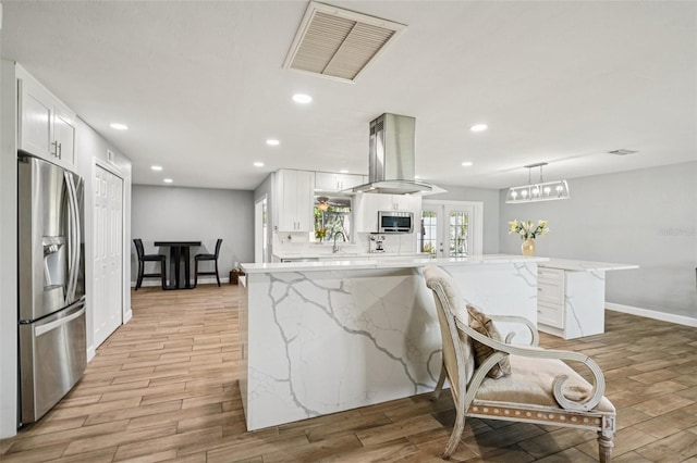 6010 Bayou Grande Blvd NE, Saint Petersburg, FL 33703 - kitchen featuring appliances with stainless steel finishes, light wood finished floors, white cabinetry, recessed lighting, and light stone countertops