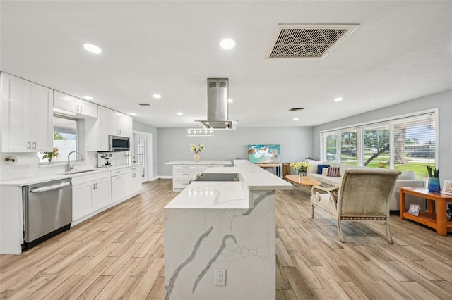 6010 Bayou Grande Blvd NE, Saint Petersburg, FL 33703 - kitchen with stainless steel dishwasher, light wood-type flooring, a center island with sink, white cabinets, and light stone countertops