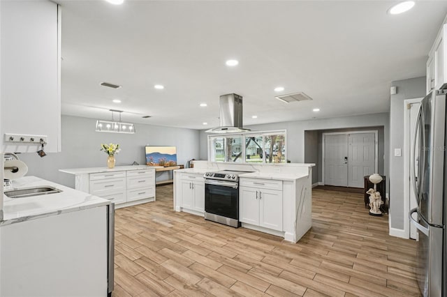 6010 Bayou Grande Blvd NE, Saint Petersburg, FL 33703 - kitchen with appliances with stainless steel finishes, island range hood, white cabinets, light wood-type flooring, and recessed lighting