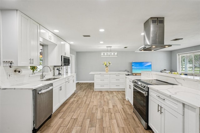 6010 Bayou Grande Blvd NE, Saint Petersburg, FL 33703 - kitchen featuring stainless steel appliances, island range hood, light wood-style floors, white cabinets, and recessed lighting