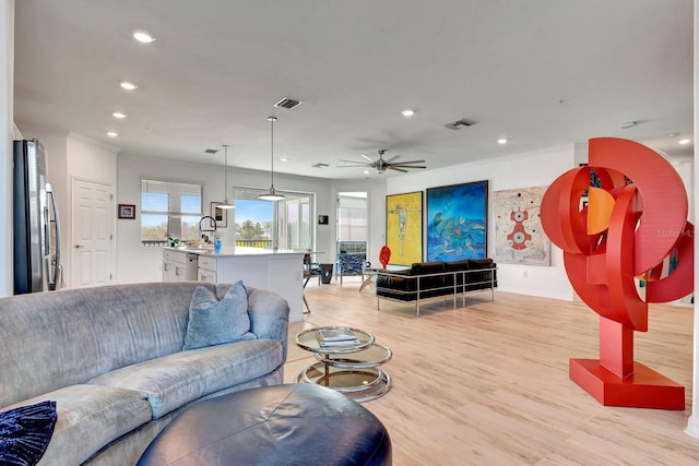 915 Tidewater Shores Loop, Bradenton, FL 34208 - living room with light wood finished floors, recessed lighting, crown molding, a ceiling fan, and baseboards