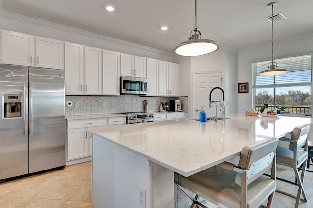 915 Tidewater Shores Loop, Bradenton, FL 34208 - kitchen featuring stainless steel appliances, a sink, decorative backsplash, ornamental molding, and an island with sink