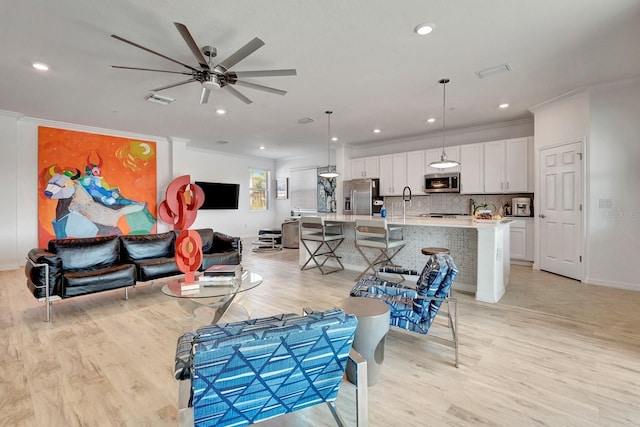 915 Tidewater Shores Loop, Bradenton, FL 34208 - living area with crown molding, a ceiling fan, light wood-style floors, recessed lighting, and baseboards