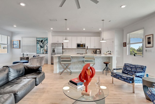 915 Tidewater Shores Loop, Bradenton, FL 34208 - living area featuring crown molding, light wood finished floors, recessed lighting, a ceiling fan, and baseboards