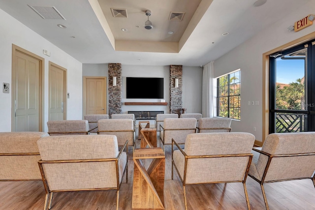 915 Tidewater Shores Loop, Bradenton, FL 34208 - living room featuring wood finished floors, a raised ceiling, a glass covered fireplace, and recessed lighting