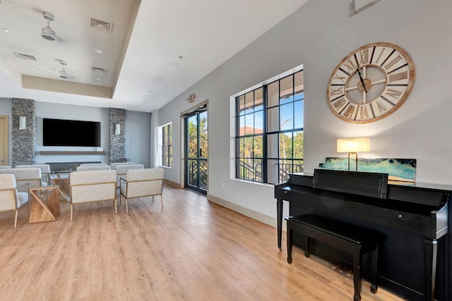 915 Tidewater Shores Loop, Bradenton, FL 34208 - living room with a raised ceiling, light wood-style floors, and baseboards