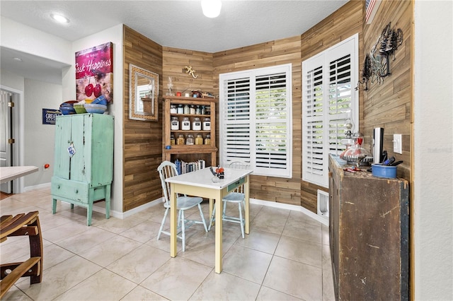 5296 Slater Rd, Spring Hill, FL 34608 - dining room featuring wood walls, light tile patterned floors, and a textured ceiling