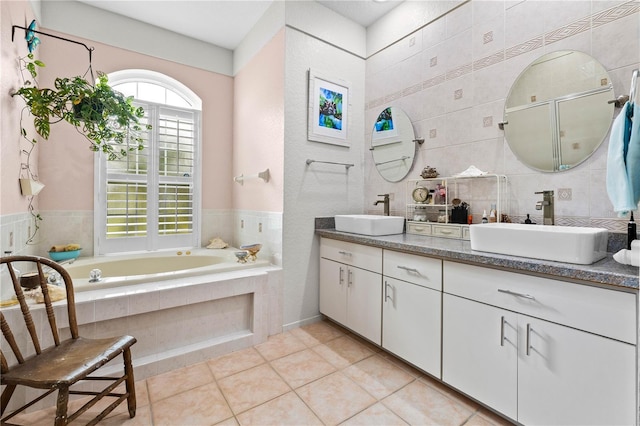 5296 Slater Rd, Spring Hill, FL 34608 - bathroom with double vanity, a garden tub, tile patterned floors, and tile walls