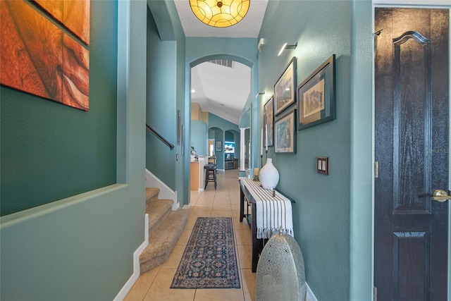 35819 Diamond Head Ct, Zephyrhills, FL 33541 - hallway with arched walkways, light tile patterned floors, baseboards, stairway, and vaulted ceiling