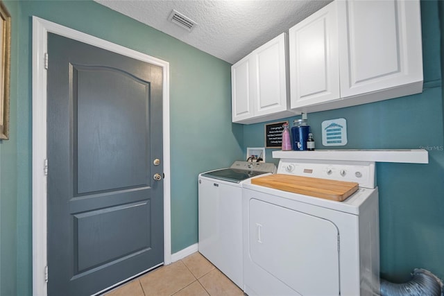 35819 Diamond Head Ct, Zephyrhills, FL 33541 - laundry room featuring washing machine and clothes dryer, light tile patterned floors, cabinet space, a textured ceiling, and baseboards