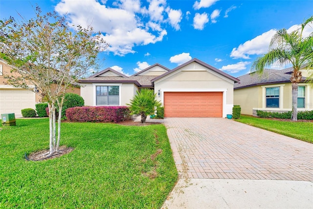 single story home featuring decorative driveway, a garage, stucco siding, and a front lawn