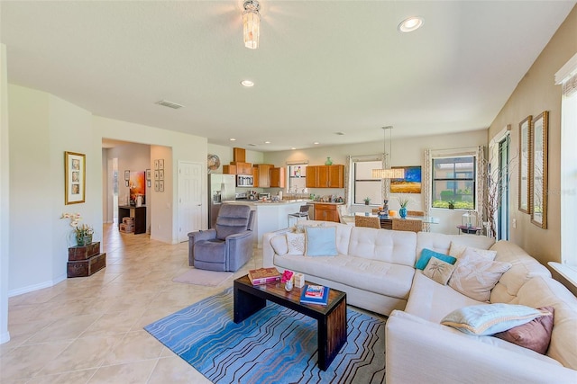 living area featuring light tile patterned floors, recessed lighting, and baseboards