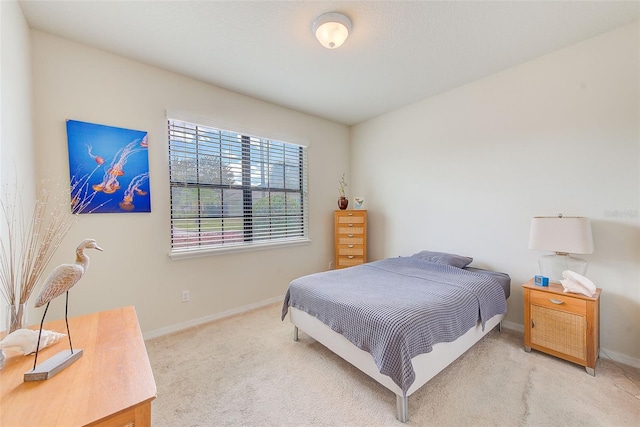 bedroom featuring light colored carpet and baseboards