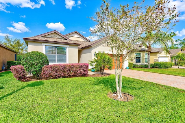 single story home featuring driveway, a front yard, stucco siding, and a garage