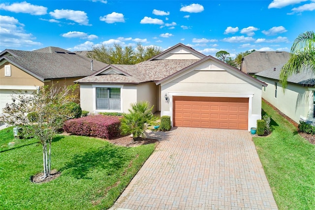 ranch-style house with a garage, a front lawn, decorative driveway, and stucco siding
