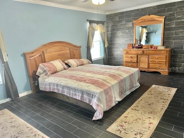 bedroom featuring ornamental molding, wood tiled floors, baseboards, and ceiling fan