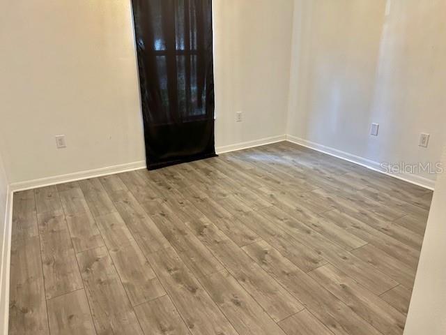 empty room featuring wood finished floors and baseboards