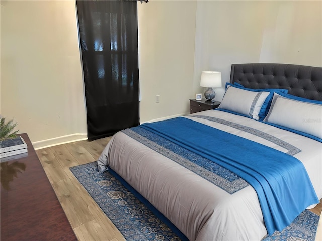 bedroom featuring wood finished floors and baseboards