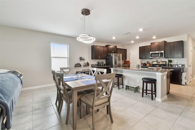 dining area with a textured ceiling, visible vents, baseboards, light tile patterned flooring, and recessed lighting