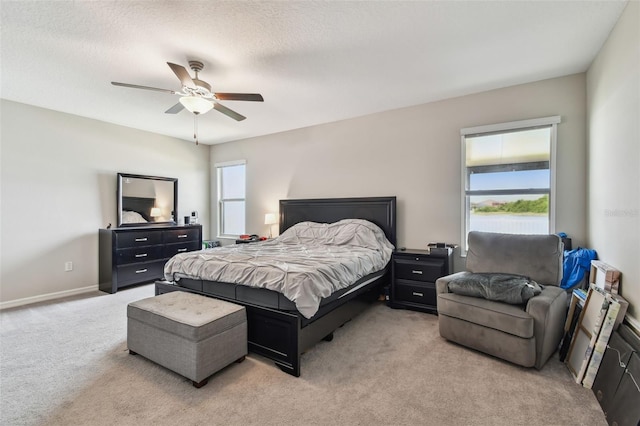 bedroom with light colored carpet, baseboards, and a ceiling fan