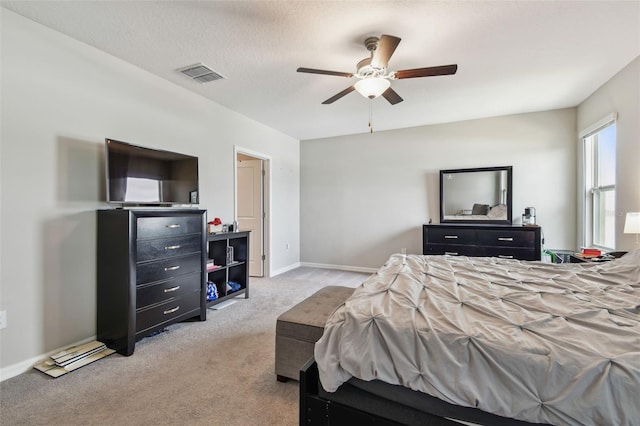 bedroom with a ceiling fan, light carpet, visible vents, and baseboards