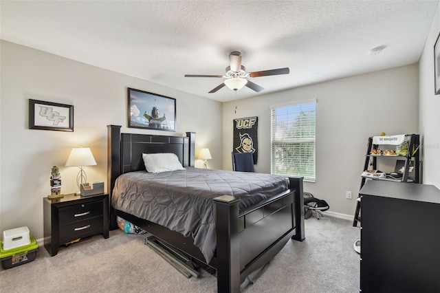 bedroom featuring a textured ceiling, light carpet, baseboards, and ceiling fan
