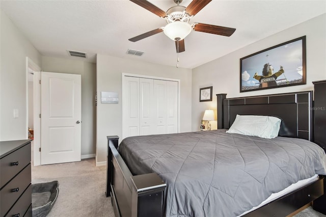 bedroom featuring light colored carpet, a closet, visible vents, and a ceiling fan