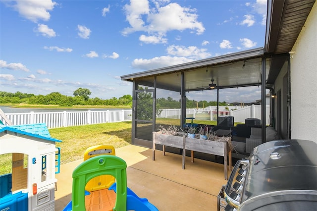 view of patio with a sunroom, a water view, fence, and grilling area