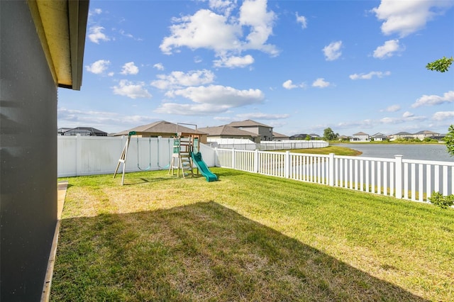 view of yard with a fenced backyard, a water view, a playground, and a residential view