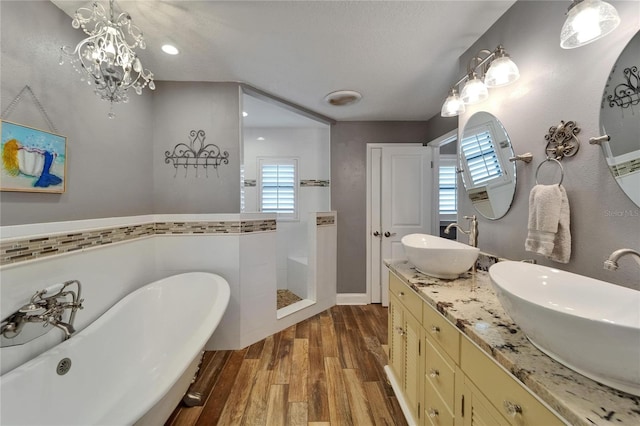 bathroom with wood finished floors, healthy amount of natural light, a freestanding tub, walk in shower, and recessed lighting