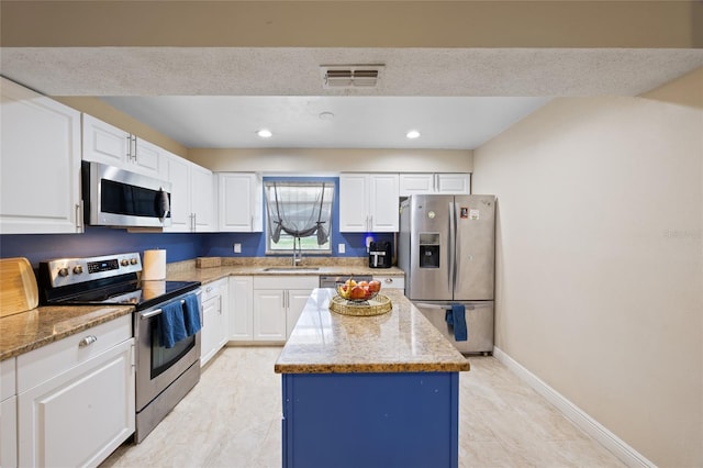 916 Shangri La Dr, Seffner, FL 33584 - kitchen featuring appliances with stainless steel finishes, a sink, a kitchen island, light stone counters, and recessed lighting