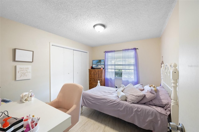 916 Shangri La Dr, Seffner, FL 33584 - bedroom with a closet, a textured ceiling, and wood finished floors