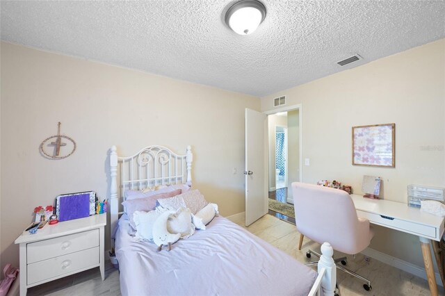 916 Shangri La Dr, Seffner, FL 33584 - bedroom featuring a textured ceiling, a desk, and wood finished floors