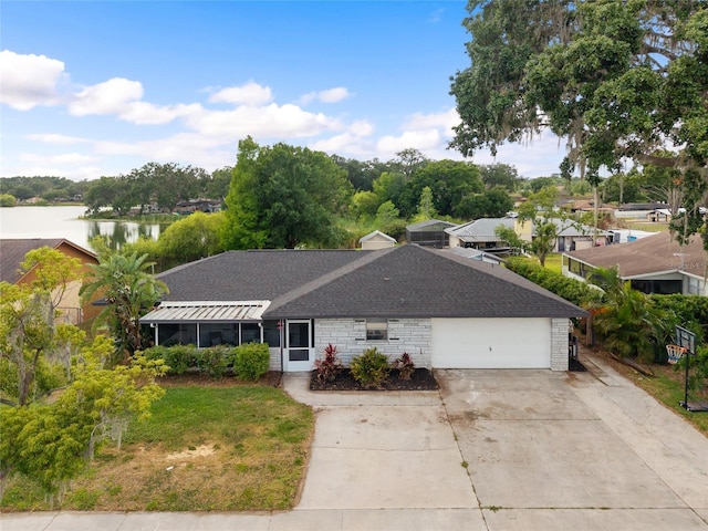 916 Shangri La Dr, Seffner, FL 33584 - ranch-style home featuring driveway, a shingled roof, a garage, and a water view