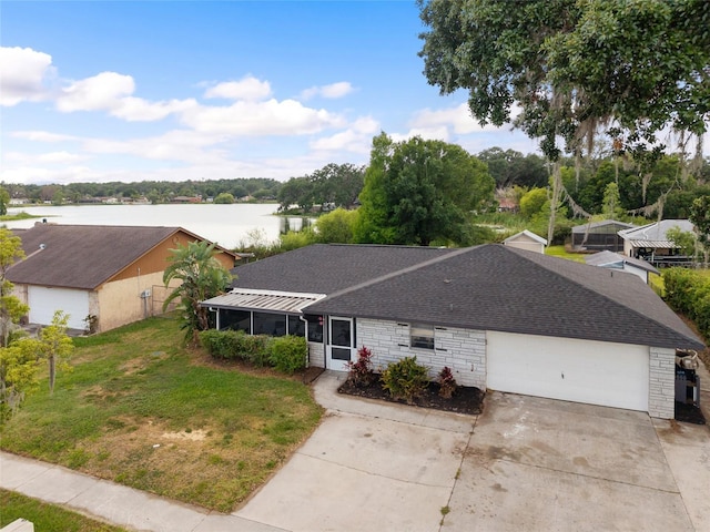 916 Shangri La Dr, Seffner, FL 33584 - ranch-style house featuring a shingled roof, a water view, concrete driveway, a garage, and a sunroom