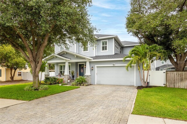 3611 W Royal Palm Cir, Tampa, FL 33629 - view of front of home featuring roof with shingles, a porch, decorative driveway, a gate, and stone siding