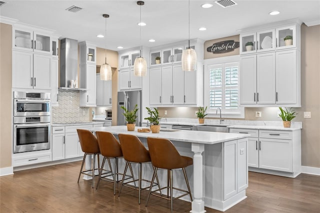 3611 W Royal Palm Cir, Tampa, FL 33629 - kitchen featuring a sink, stainless steel appliances, a kitchen island, dark wood-style flooring, and white cabinetry