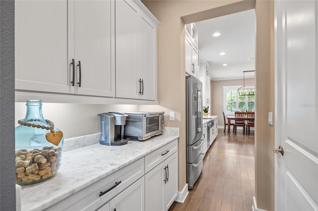 3611 W Royal Palm Cir, Tampa, FL 33629 - kitchen featuring freestanding refrigerator, recessed lighting, white cabinetry, hardwood / wood-style flooring, and light stone counters