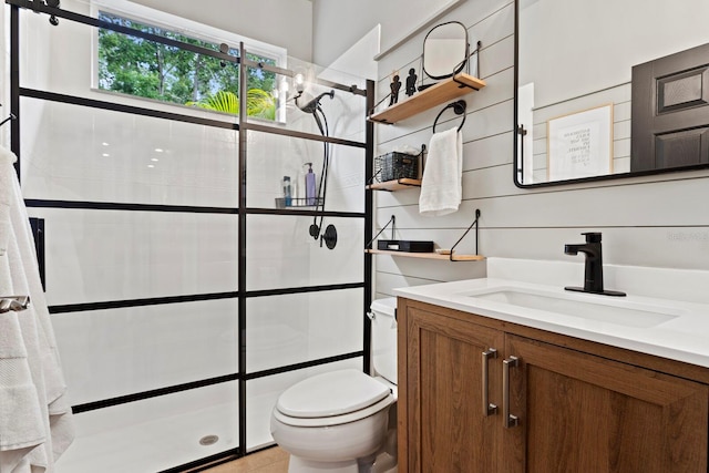 bathroom featuring tiled shower, toilet, and vanity
