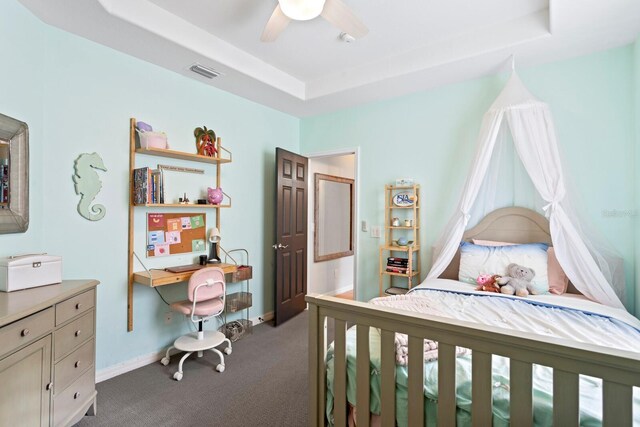 bedroom featuring carpet, a tray ceiling, a ceiling fan, and baseboards