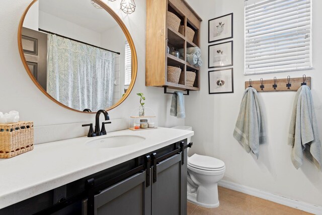 bathroom featuring tile patterned floors, toilet, vanity, and baseboards