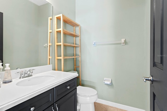 bathroom with toilet, tile patterned floors, baseboards, and vanity