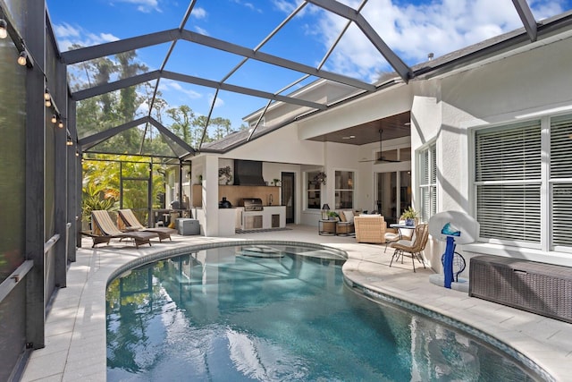 outdoor pool featuring an outdoor kitchen, a patio area, outdoor lounge area, and a ceiling fan