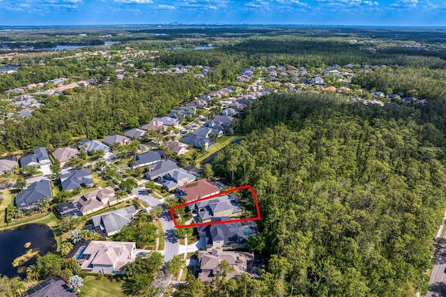aerial overview of property's location with a forest, property parcel outlined, and nearby suburban area